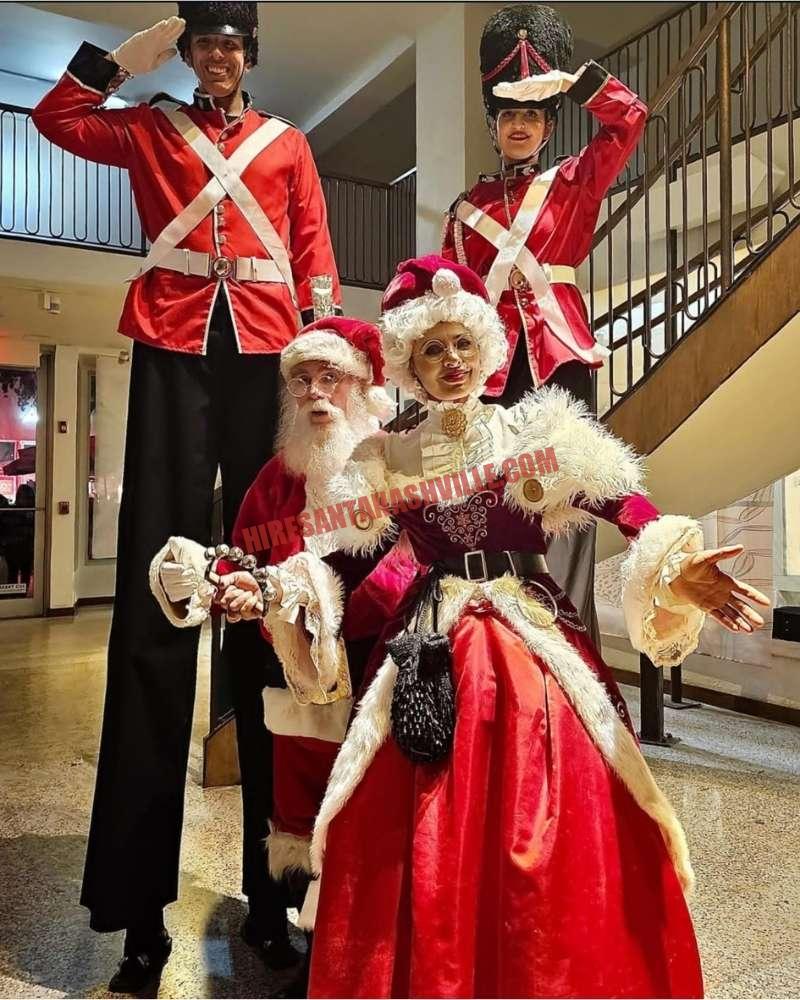 Corporate Santa in Nashville indoors with two stilt nutcracker soldiers, Santa, and Mrs. Claus.